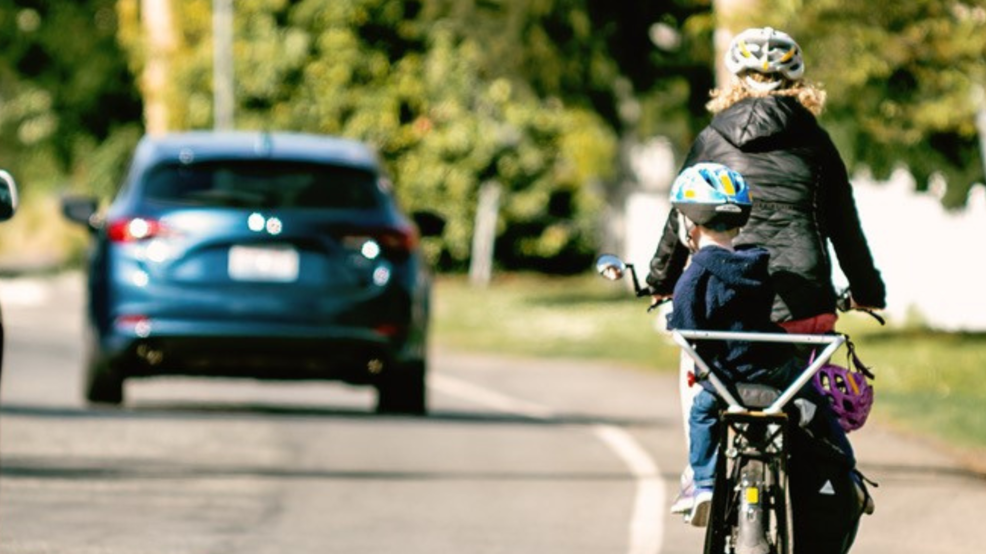 Cyclist with child on busy street